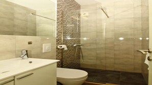 A bathroom with a toilet, a sink, and a shower area. - Apartment Dubreta With Balcony (Konavle)