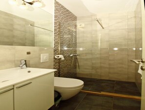 A bathroom with a toilet, a sink, and a shower area. - Apartment Dubreta With Balcony (Konavle)