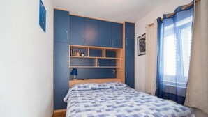 A bedroom with a bed, a wardrobe, and a shelf unit. - Three Bedroom Apartment With Terrace and sea View (Postira)
