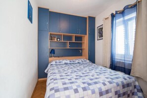 Ein Schlafzimmer mit einem Bett, einem Kleiderschrank und einem Regal.