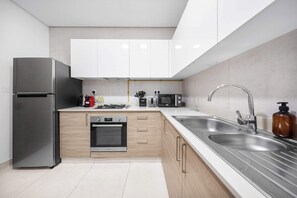 Eine moderne Küche mit Edelstahlgeräten, Holzschränken und einer Spüle.