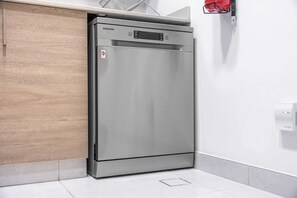 Ein Samsung-Kühlschrank in einer Küche mit Holzschrank und weiß gefliestem Boden.