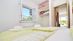 Habitación de hotel con cama, ventana y puerta que da a un balcón.