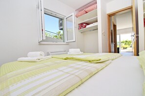 A hotel room with a bed, a window, and a door leading to a balcony. - Apartments Gusti - One Bedroom Apartment With Terrace and Sea View (Janjina)