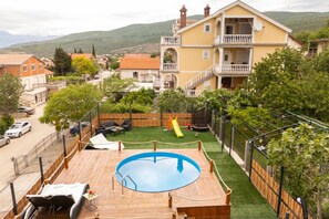 Ein Wohngebiet mit Swimmingpool, Rutsche und umzäuntem Garten.