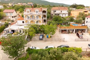 Ein Wohngebiet mit einem zweistöckigen Haus, einem Balkon und einem eingezäunten Garten mit Pool.