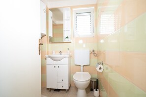 Ein kleines Badezimmer mit Toilette, Waschbecken und Spiegel.