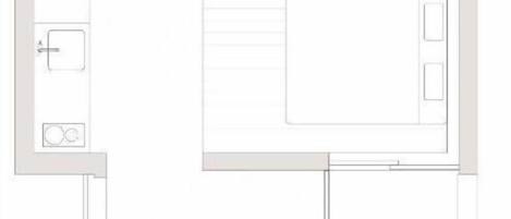 A floor plan of a hotel room with a bathroom, a small kitchenette, and a seating area.