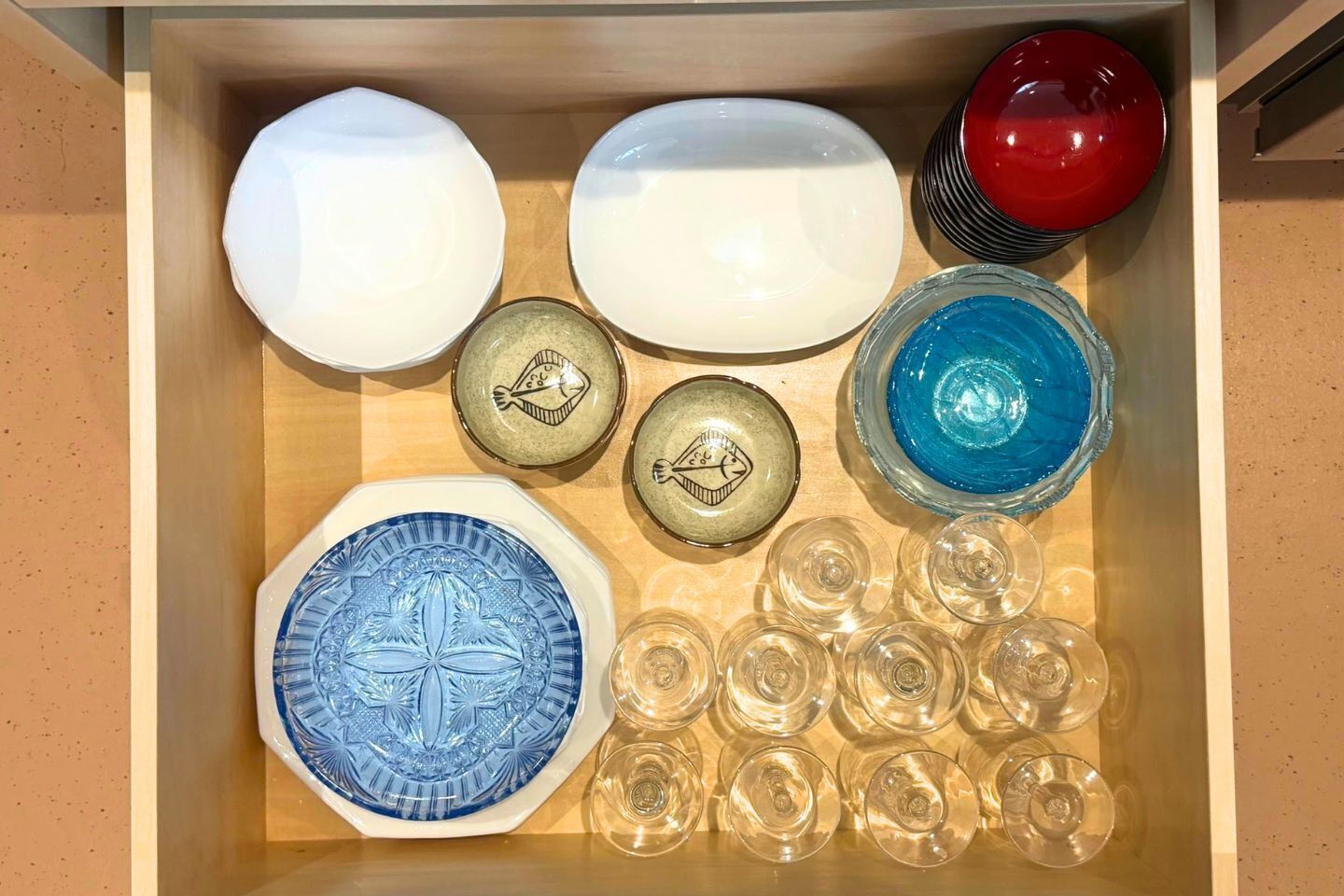 En skuffe med forskelligt glas, tallerkener, skåle og glas.