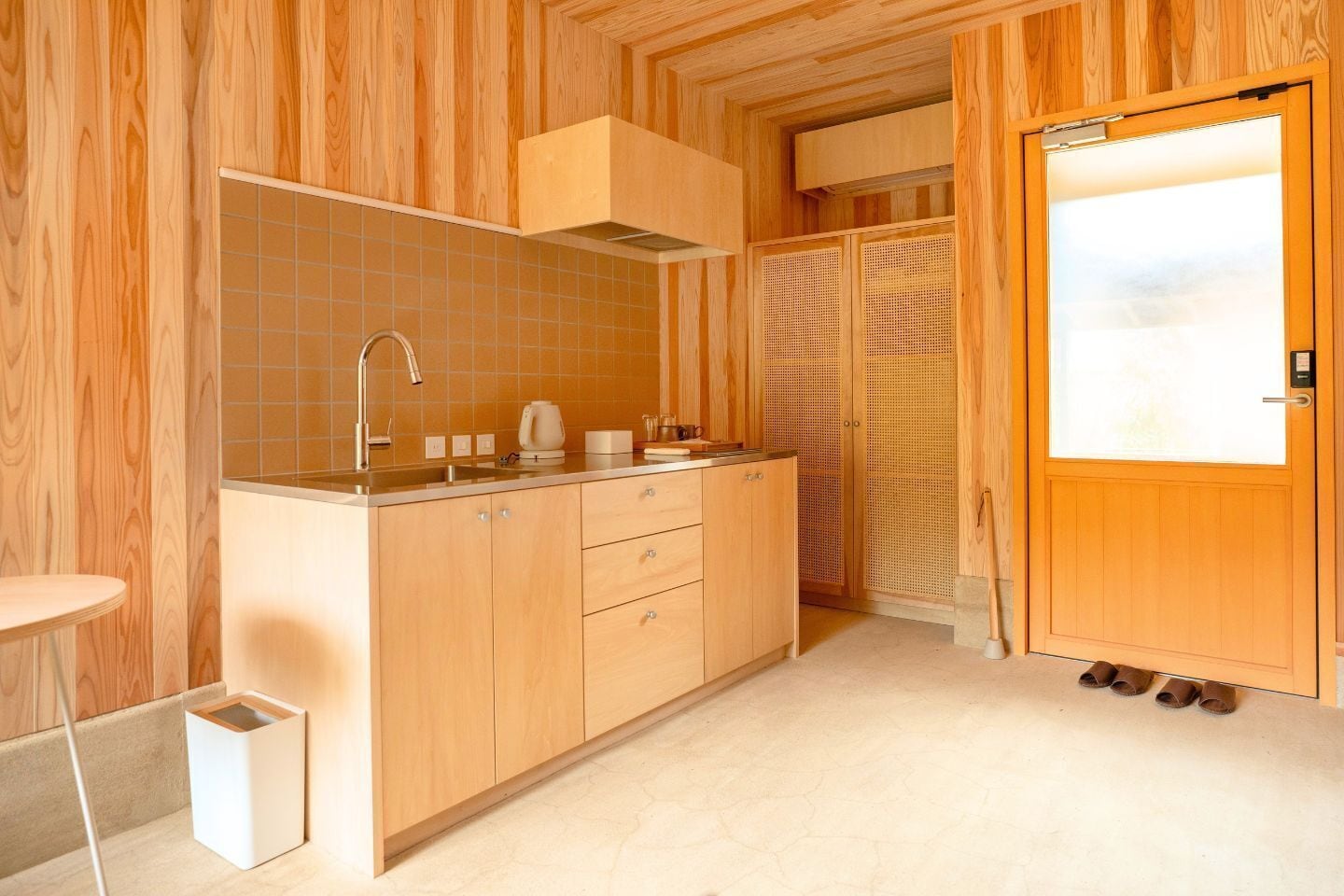 A modern kitchen with wooden cabinetry, a stainless steel sink, and a built-in stove.