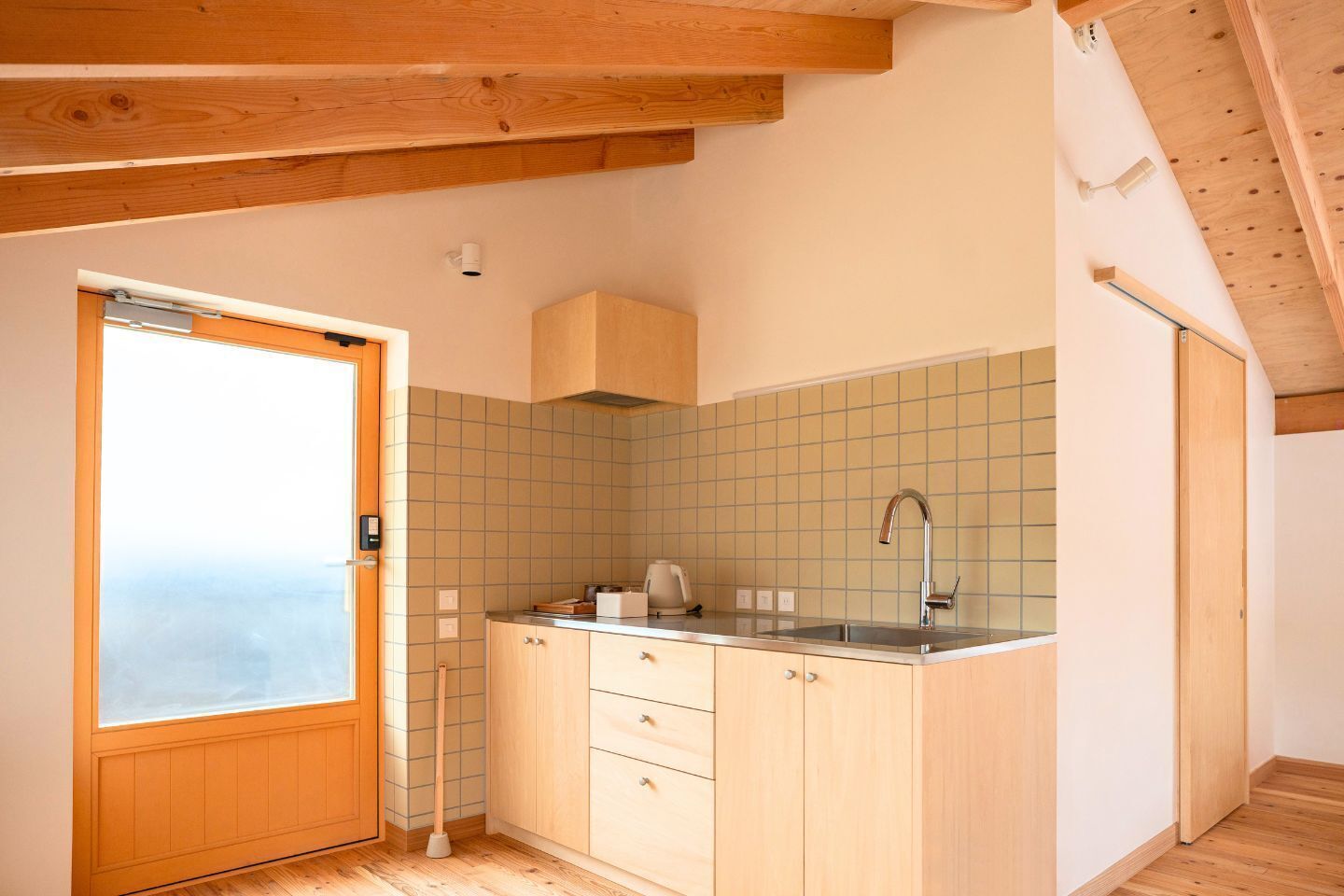 A compact kitchen with a wooden countertop, a sink, and a window.