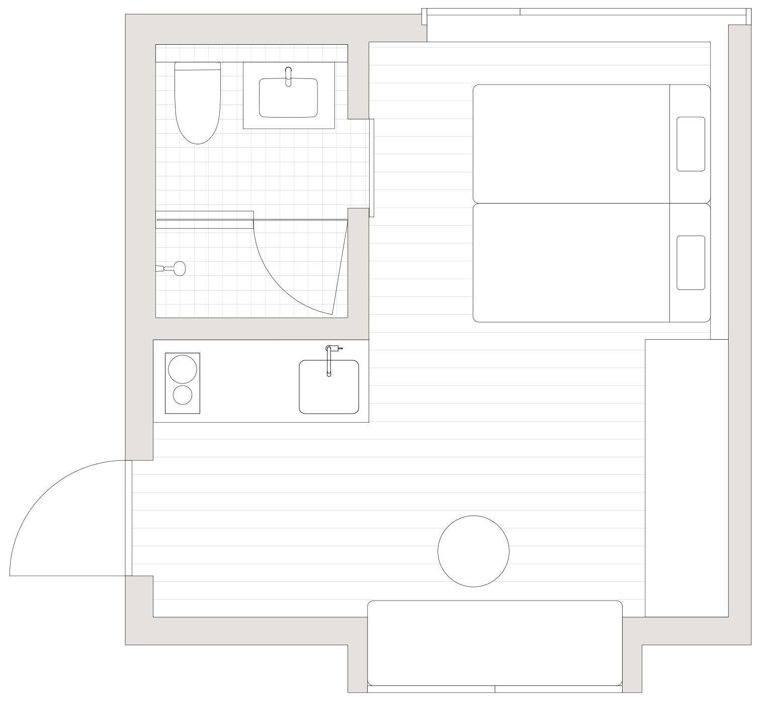 A floor plan of a hotel room with a bathroom, a small kitchenette, and a circular seating area.