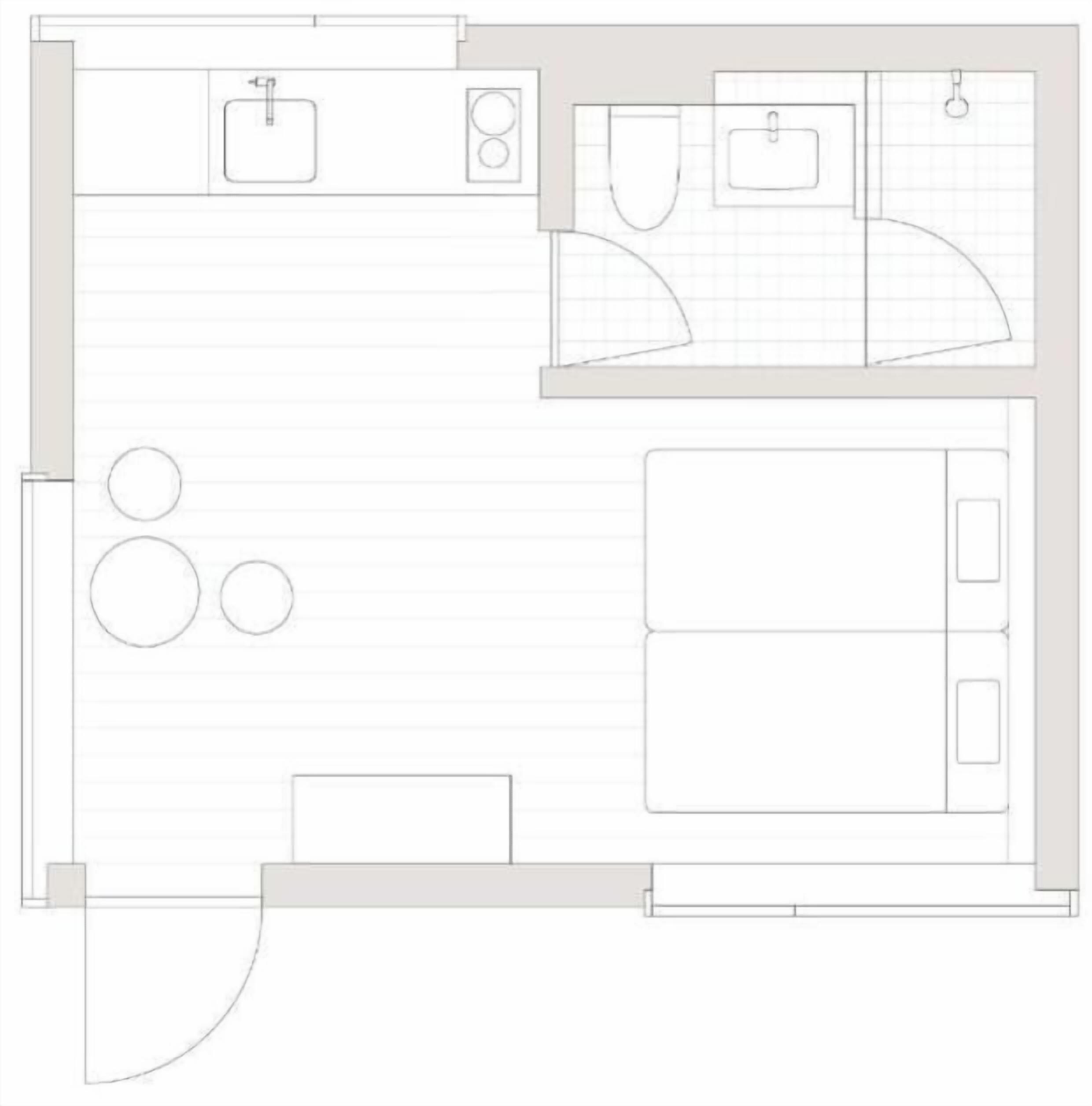 Un plan d’étage d’une chambre d’hôtel comprenant un coin cuisine, une salle de bain, un espace salon et un lit.