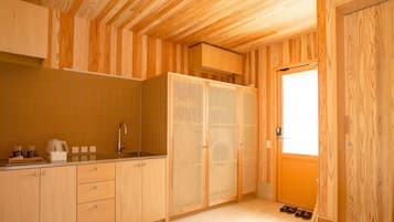 Een kleine keuken met houten kastjes, een spoelbak en een raam.