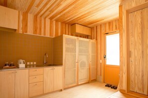 Una cocina pequeña con armarios de madera, un lavamanos y una ventana.