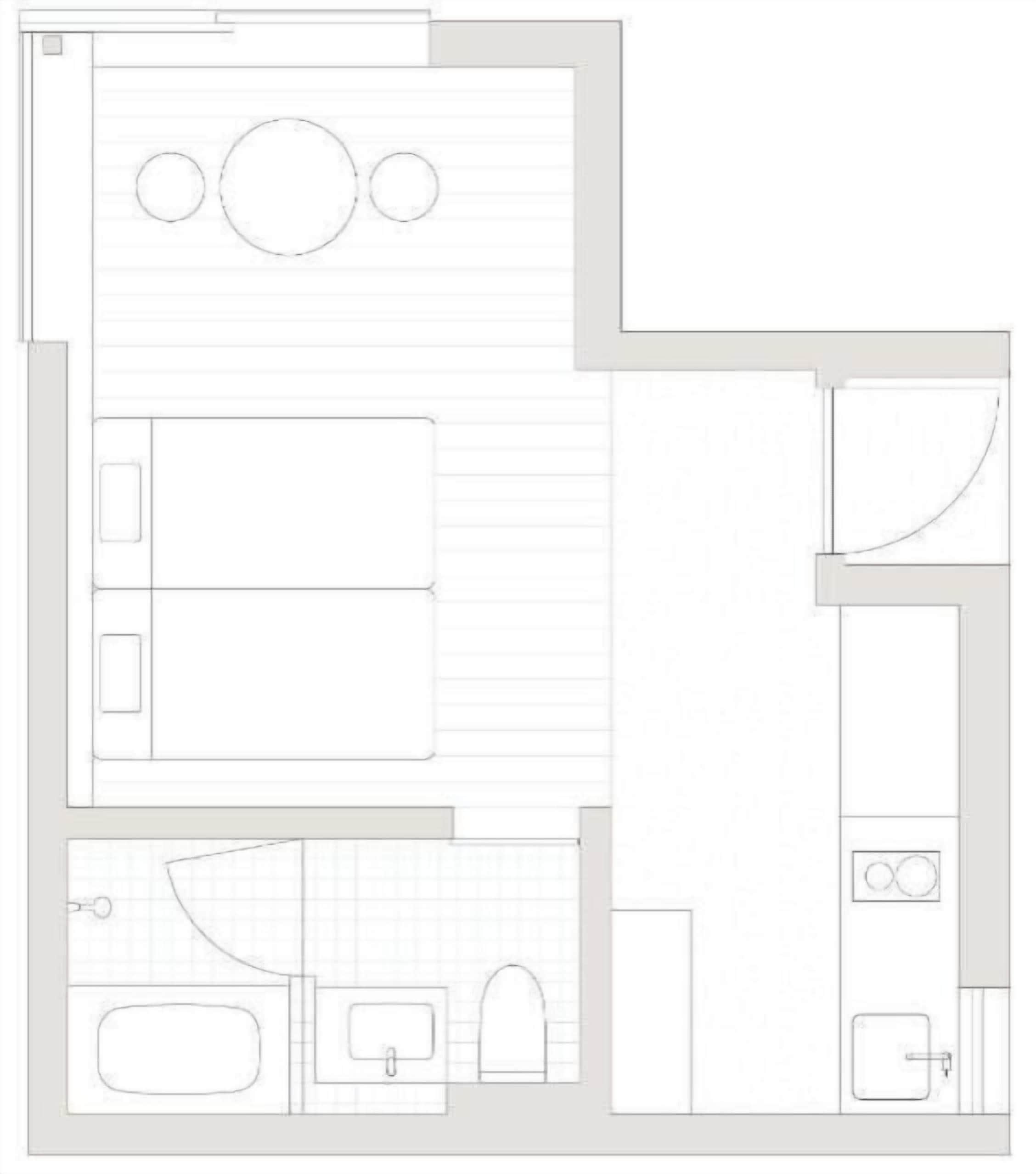 Plano de un cuarto de hotel que muestra una cama, un baño, una kitchenette y una zona de estar.