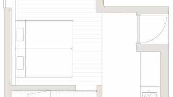 Plano de un cuarto de hotel que muestra una cama, un baño, una kitchenette y una zona de estar.