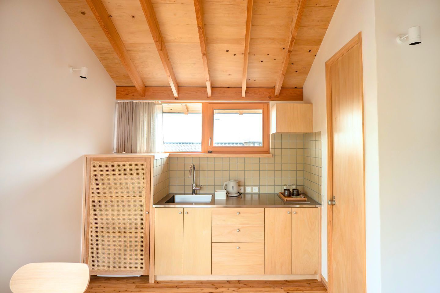 A compact kitchen with wooden cabinets, a sink, and a window.