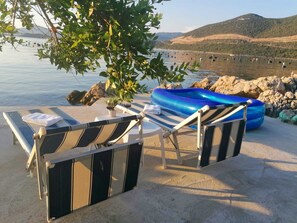 Ein Strandloungebereich mit Liegestühlen und einem blauen Luftmatratze.