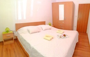 Ein Hotelzimmer mit Bett, Schrank, Nachttisch und Lampe.