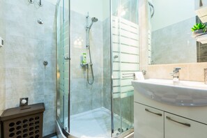 A modern bathroom with a glass shower enclosure, a white sink, and a mirror. - Charming and Historic Old Town Apartments - Twin Room (Zadar)