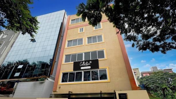 Un edificio de varios pisos con fachada de vidrio moderna y un letrero que indica que es un complejo de apartamentos gestionado por una empresa.