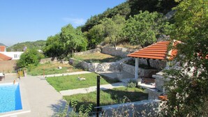 A pool area with a stone wall and a gazebo. - Holiday Home Stari Zoganj - Two Bedroom Holiday Home With Terrace and Swimming Pool (Orebic)