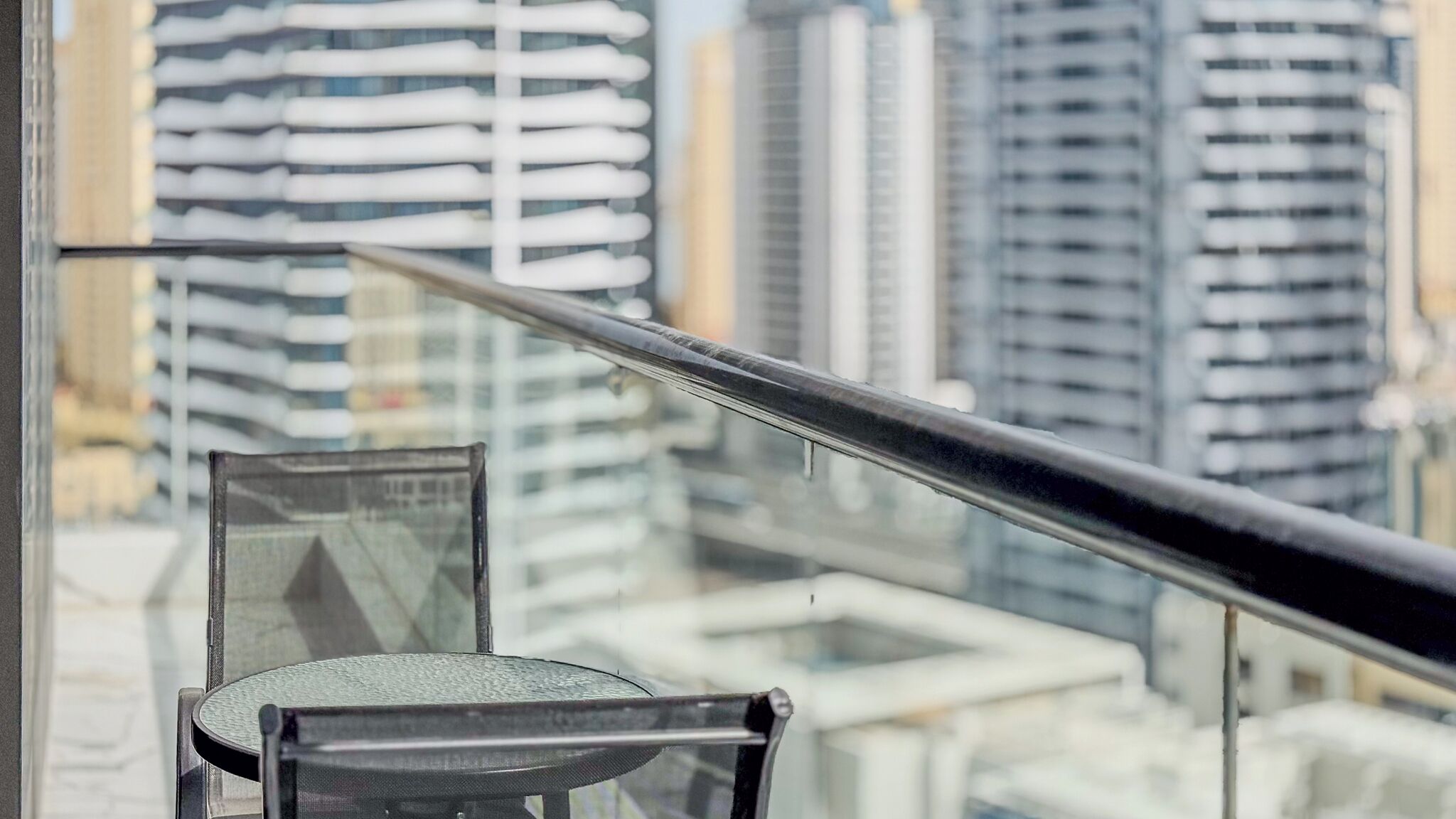 A view of a cityscape through a window with a metal railing.