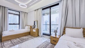 A modern hotel room with two beds, a wooden nightstand, a desk, a mirror, and large windows with curtains. - Escan Tower- Dubai Marina (Dubai)