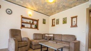 A living room with a sofa, armchair, and a coffee table. - Apartments Andre Porec - Two Bedroom Apartment With Balcony and Pool (Porec)