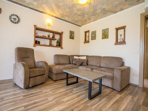 Ein Wohnzimmer mit einer Couch, einem Sessel und einem Couchtisch.