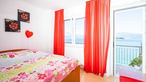 A bedroom with a bed, a window, and a balcony with a view of the sea. - Apartments Nikolina - Studio With Sea View (Lumbarda)