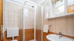 A modern bathroom with a glass shower enclosure, a toilet, a sink, and a mirror above the sink. - Apartments Nikolina - Studio With Sea View (Lumbarda)