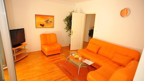 A living room with a sofa, a chair, a coffee table, a television, and a painting on the wall. - Villa Anni-two Bedroom Apartment With Terrace (Sutivan)