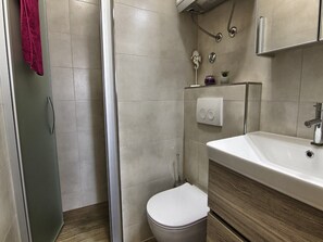 Ein Badezimmer mit Dusche, Toilette und Waschbecken.