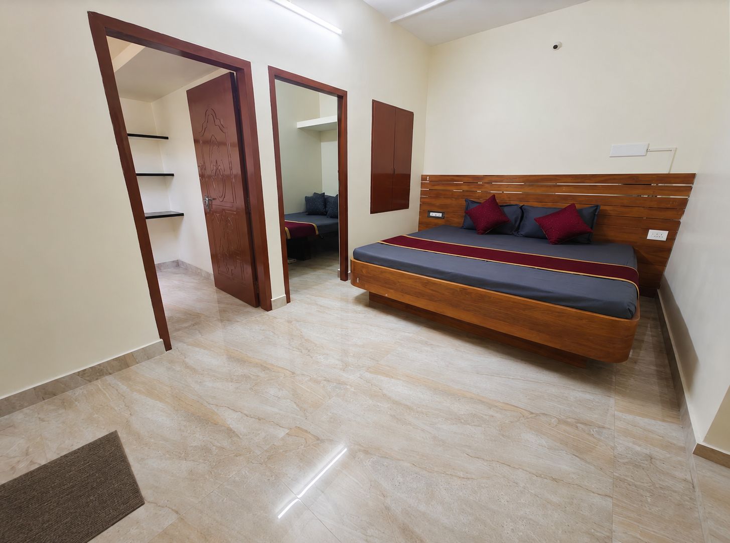 A bedroom with a bed, a wardrobe, and a door leading to another room.
