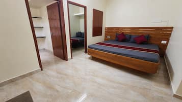 A bedroom with a bed, a wardrobe, and a door leading to another room.