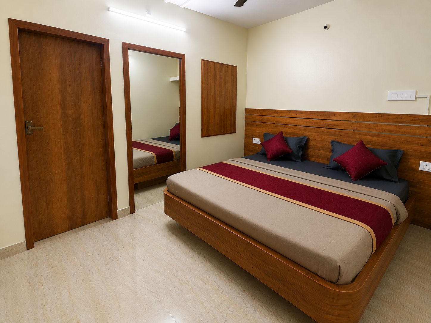 A bedroom with a wooden bed, a mirror, and a door.