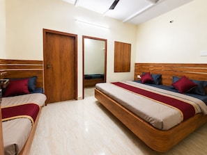 A hotel room with a large bed, a smaller bed, and a wardrobe. - Grand Eco Stay (Tiruvannamalai)