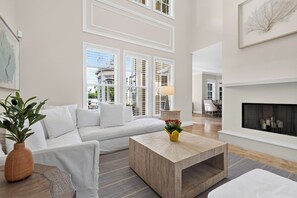 A modern living room with a sofa, a coffee table, and a fireplace. - Private Pool + Hot Tub + Boat Dock | 2-Min Walk to Beach | Beach Drive Estate (Delray Beach)