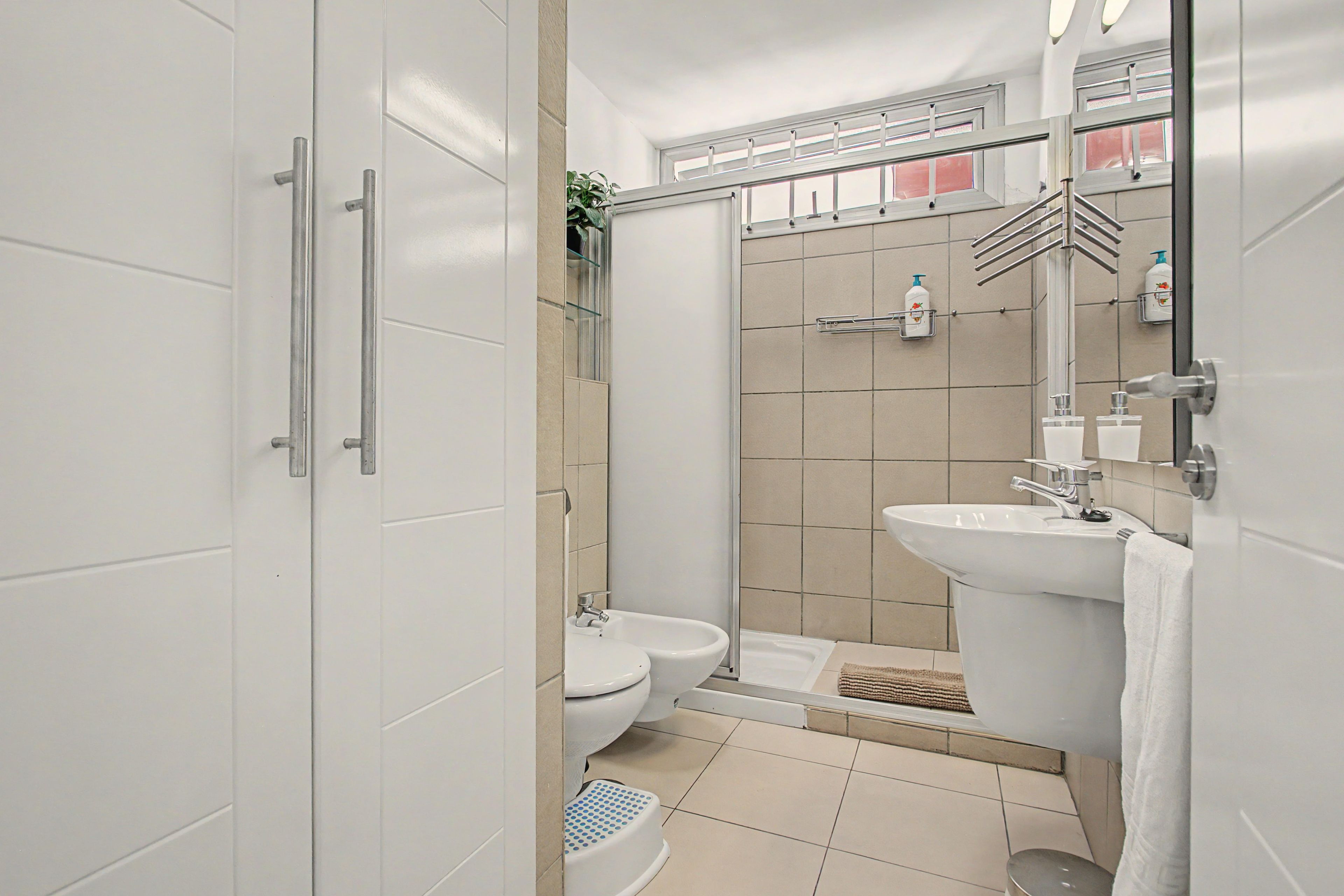 Un baño moderno con ducha, inodoro y lavamanos.
