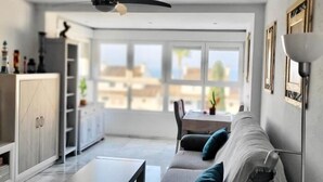 Un soggiorno moderno con divano, tavolino e zona pranzo con tavolo e sedie.