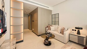 A modern living room with a sofa, coffee table, and a flat-screen TV. - Bloomfields Studio in NAS3 - Arjan Dubai (Dubai)