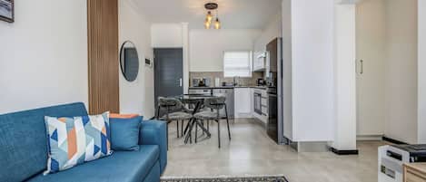 A modern apartment with a living room, dining area, and kitchen.