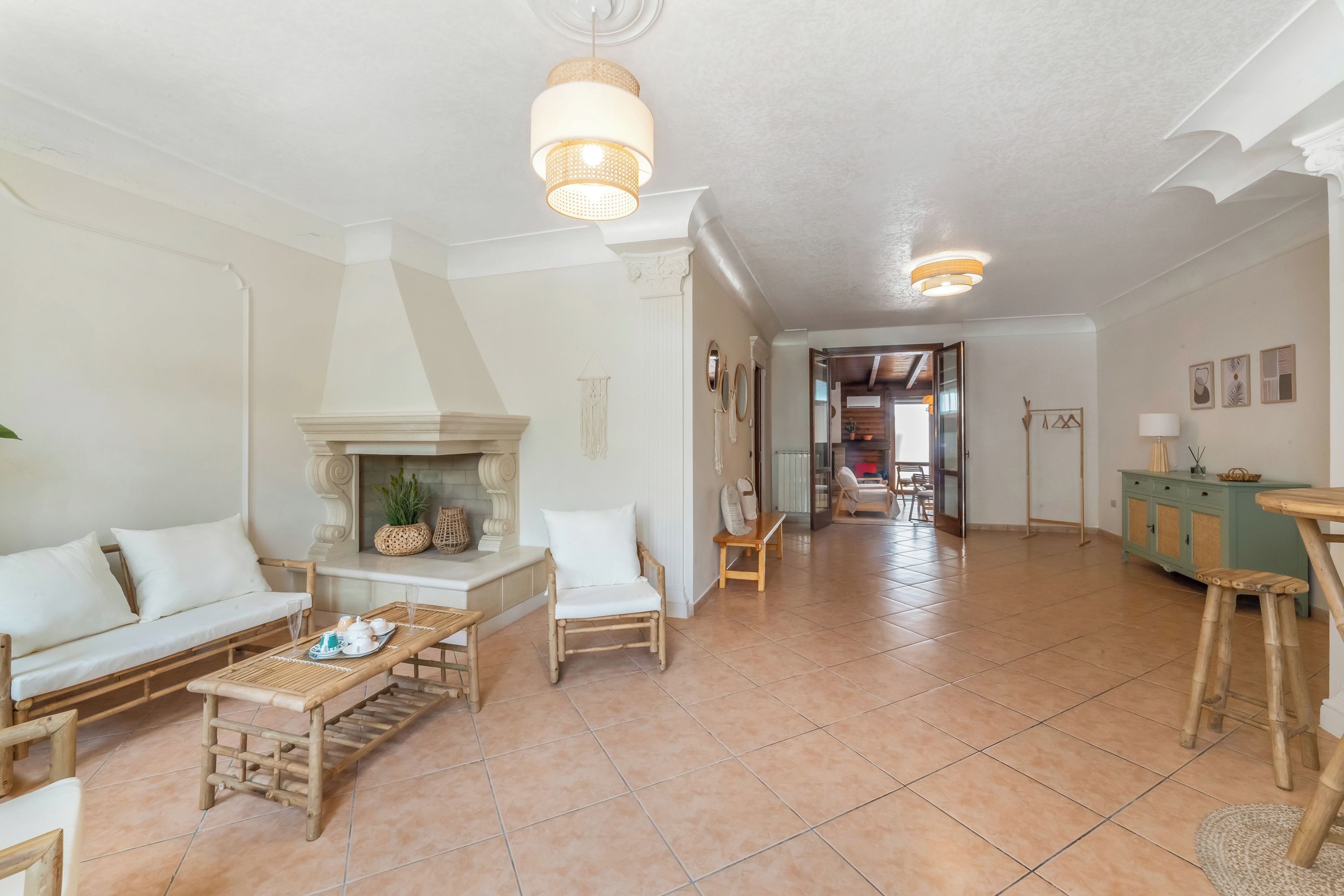 A spacious living area with a sofa, a coffee table, a fireplace, and a dining area with a table and chairs.