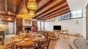 Un comedor amplio con una mesa de madera dispuesta para una comida, rodeado de sillas.