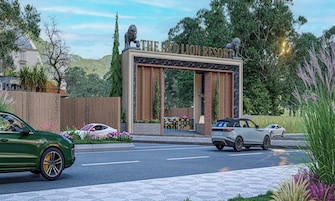 Un edificio moderno con un cartel de entrada llamativo, una estatua de león y un camino pavimentado con automóviles estacionados.