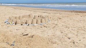 A sandy beach with a sandcastle structure.