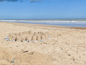 A sandy beach with a sandcastle structure.