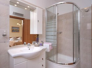A modern bathroom with a glass-enclosed shower, a white sink, and a large mirror. - One Bedroom Apartment With Balcony 3 (Jelsa)